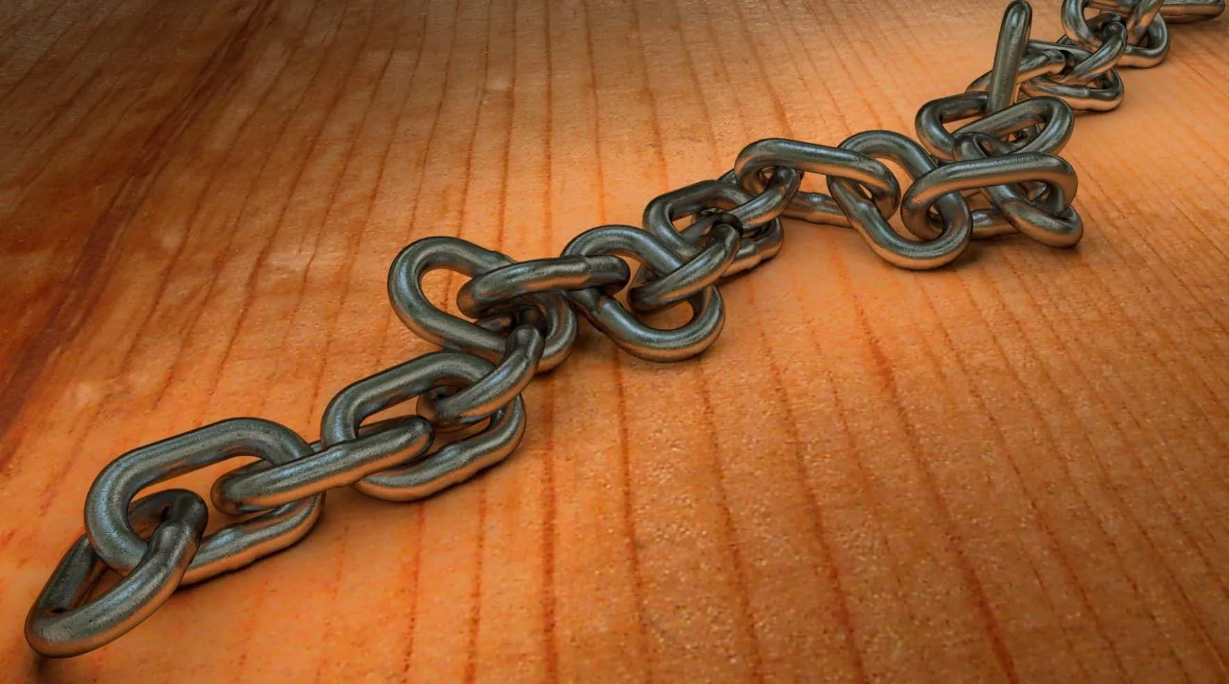 Metal chain lying diagonally across a wooden surface